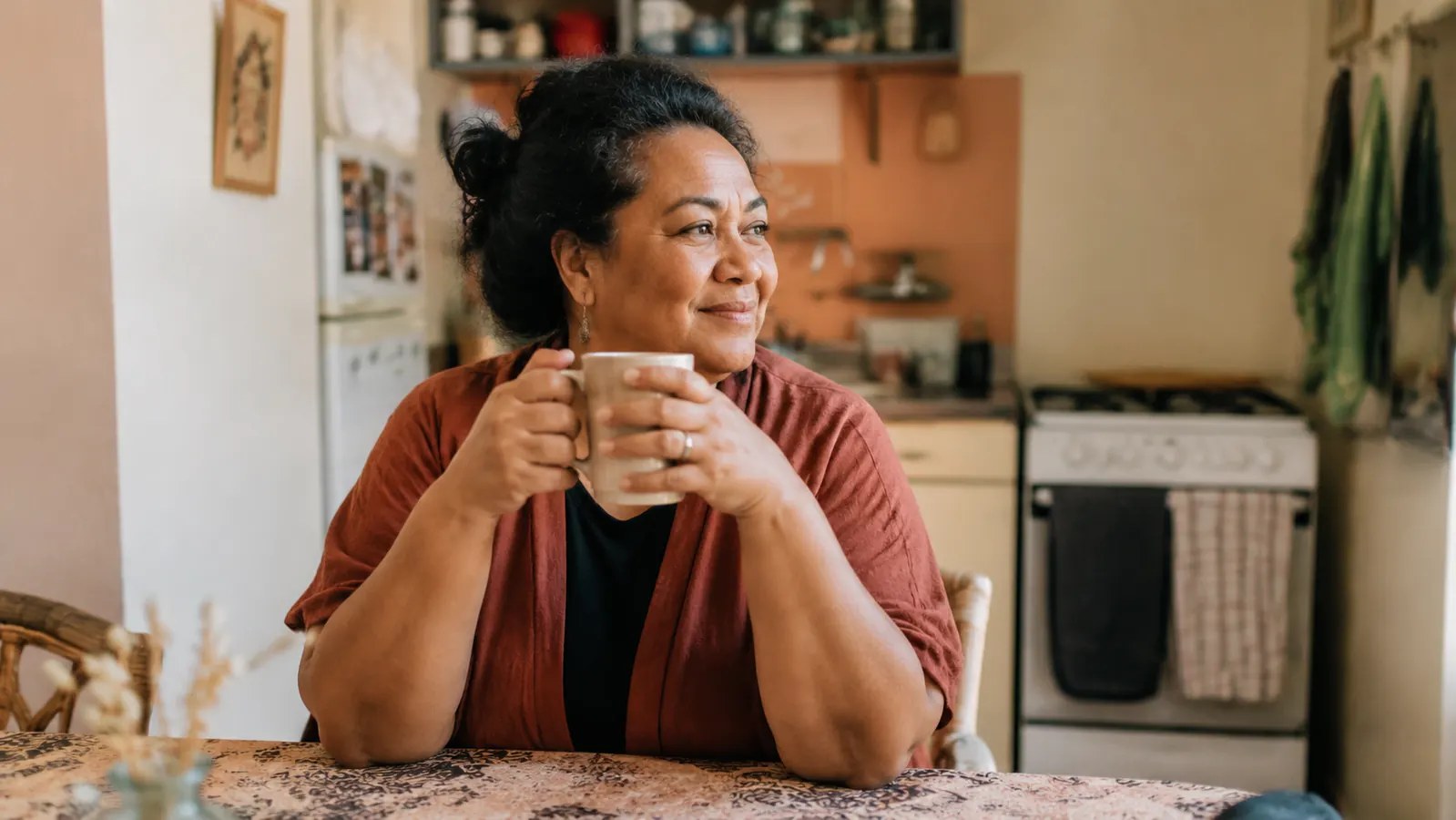 Person enjoying a morning coffee at a small table near a sunny window