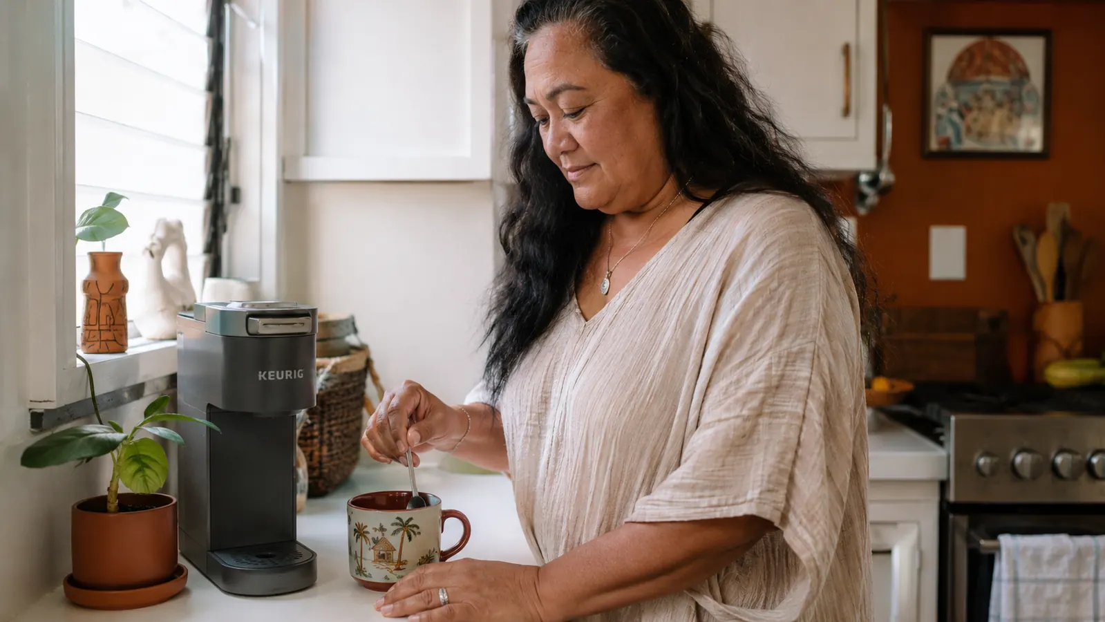 Keurig K-Mini coffee maker on a compact kitchen counter next to a steaming mug